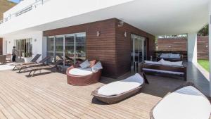 プンタ・デル・エステにあるCómodo apartamento en Torre Ocean Drive con todos los serviciosの- パティオ(ソファ、木製デッキの椅子付)