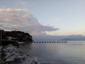 a pier stretches out over the water on a beach at B&B Rosalu - Adults Only in Sirmione