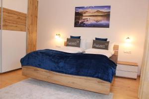 a bedroom with a large bed with a blue blanket at Ferienwohnung Auszeit Stubai in Fulpmes