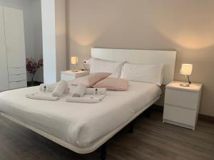 1 dormitorio con 1 cama blanca grande y 2 lámparas en Zerka Sendra, en Valencia