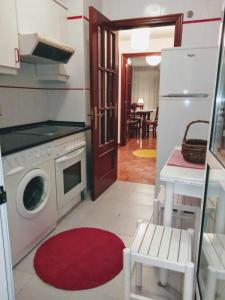 eine Küche mit Waschmaschine und Trockner neben einer Tür in der Unterkunft APARTAMENTO ALFICA VUT-981-AS in Llanes