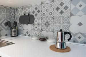 encimera de cocina con tetera y azulejos en Aquila Sveva Domus, en Ragusa