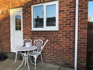 two chairs and a table in front of a brick building at spacious 2 bedroom house in Shotton