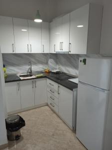 a kitchen with white cabinets and a white refrigerator at Lovely Apartment 2 in Golem