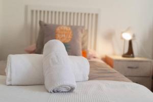 un montón de toallas encima de una cama en Apartamento suite San Roque. Street Lecha Marzo., en Sevilla