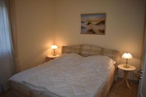 een slaapkamer met een bed en 2 tafels met lampen bij Anne Marie in Barendorf