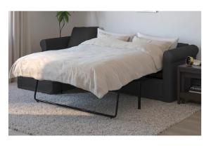 1 cama con marco negro y silla en City Apartments Soltau, en Soltau