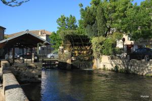 a river with cars parked next to a building at La Fenière in Sault-de-Vaucluse