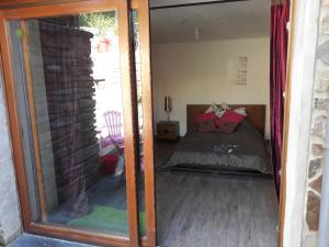 a reflection of a bedroom with a bed in a mirror at Logement du Paquis in Les Mazures