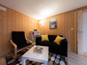 ein Wohnzimmer mit einem Sofa und einem Stuhl in der Unterkunft Ferienwohnung Meiringen "Engelhorn" in Meiringen