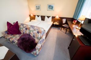ein Wohnzimmer mit einem Bett und einem Sofa in der Unterkunft Hotel Goldener Hirsch in Reutte