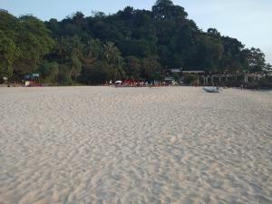 uma praia arenosa com um pequeno barco em Mook Paradise Bungalow em Ko Mook