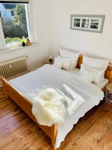 ein Bett mit einer weißen Decke und Kissen darauf in der Unterkunft An der Uniklinik, Apartment mit eigener Küche und renoviertem Badezimmer, Zentrale Lage in Homburg