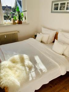 a white bed with a white blanket on it at An der Uniklinik, Apartment mit eigener Küche und renoviertem Badezimmer, Zentrale Lage in Homburg