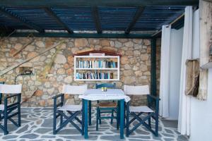 a table and chairs in front of a stone wall at Sea View Studios in Amoopi