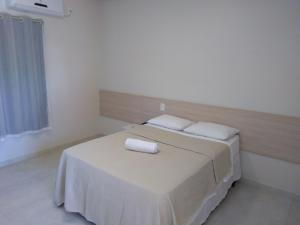 ein Schlafzimmer mit einem Bett mit zwei Kissen darauf in der Unterkunft Hotel Portal do Corrente in Santa Maria da Vitória