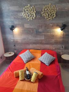 a bed with a colorful blanket and pillows on it at Bed and Breakfast P&P Nîmes-Centre in Nîmes