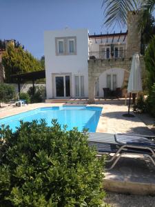 a villa with a swimming pool in front of a house at Drouseia Villa in Droushia