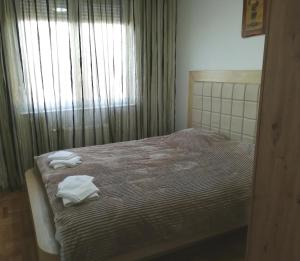 a bedroom with a bed with two towels on it at Apartman Bajka Valjevo in Valjevo