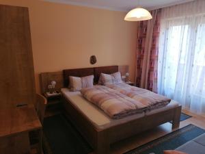 ein Schlafzimmer mit einem Bett in einem Zimmer mit einem Fenster in der Unterkunft Ferienhaus Mattersberger in Oberlienz