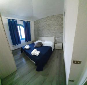 een slaapkamer met een bed met twee handdoeken erop bij Li Piri in San Teodoro