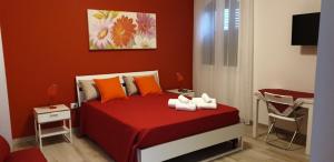 una camera da letto con un letto con lenzuola rosse e cuscini arancioni di AleMar a Porto Cesareo