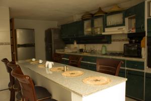 a kitchen with a table with chairs and a counter top at Casa Bachué Hotel Boutique in Chía