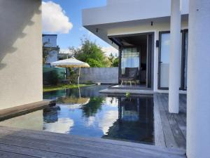a house with a swimming pool next to a house at Ohana Retreat Villa in Mont Choisy