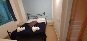 a small bedroom with a bed with white shoes on it at Li Piri in San Teodoro