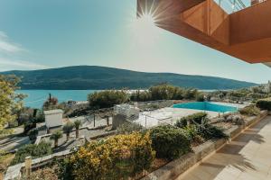 a house with a swimming pool and a view of the water at Acacia Hills B1 in Đenovići