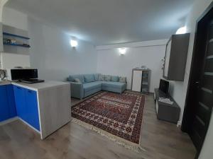 Felicita في براشوف: غرفة معيشة مع أريكة زرقاء ومطبخ