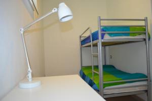 a bunk bed room with a lamp and a bunk bed with a ladder at White Dream Spotorno in Spotorno