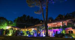 een groep mensen die 's nachts voor een gebouw staan bij la casa rossa nel bosco in Cantù