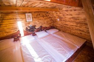 Zimmer im Dachgeschoss mit einem Bett in einem Blockhaus in der Unterkunft Domačija Paternoster in Litija