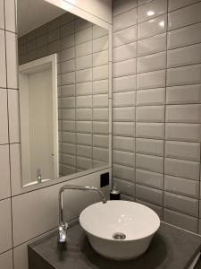 W łazience znajduje się biała umywalka i lustro. w obiekcie Near Ozas Studio w Wilnie