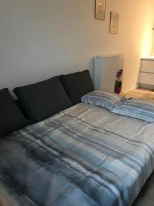 a bed with a blue comforter in a room at Residentie Palace Zeebrugge in Zeebrugge