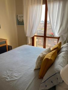 una camera da letto con letto, cuscini e finestra di Tiraboschi apartment a Modena
