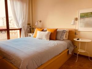 1 cama con almohadas de color naranja y blanco y ventana en Tiraboschi apartment, en Módena