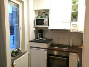 a small kitchen with a microwave and a sink at StarHomes Oulu, double in Oulu