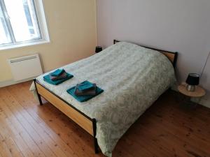 a bedroom with a bed with two towels on it at Les orchidées in Picauville