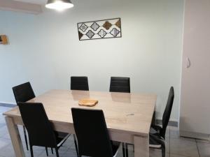 a dining room with a table and chairs at Les orchidées in Picauville +3 photos