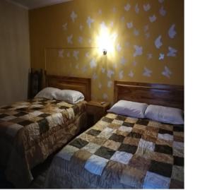2 Betten in einem Hotelzimmer mit Vögeln an der Wand in der Unterkunft Mi Angeline in Sucre