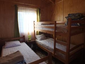 Dos literas en una habitación con ventana. en Cabañas Vista Hermosa, en El Quisco