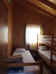 Dos literas en una habitación con ventana. en Cabañas Vista Hermosa, en El Quisco