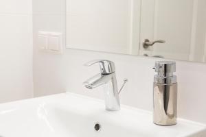 a bathroom sink with a chrome faucet at Green Hill Apartments in Kaunas +34 photos