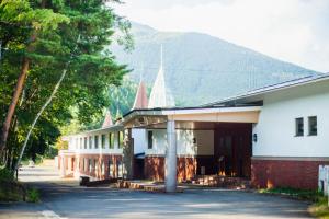 un groupe de bâtiments avec une montagne en arrière-plan dans l'établissement Arcadia, à Nagano