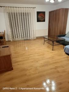 a living room with a glass table and a couch at Apartament Komorniki in Komorniki