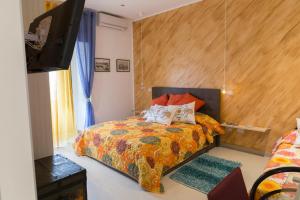 una camera da letto con un letto e una TV a schermo piatto di Casa Alcalà Deluxe a Catania