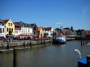 a boat is docked at a dock in a town at Haus Ramona in Struckum