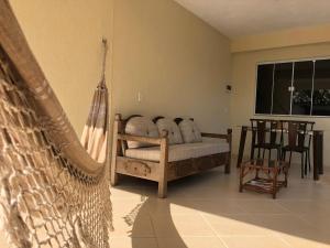 a room with a hammock and a table and chairs at Flats Ponta do Sapê in Angra dos Reis